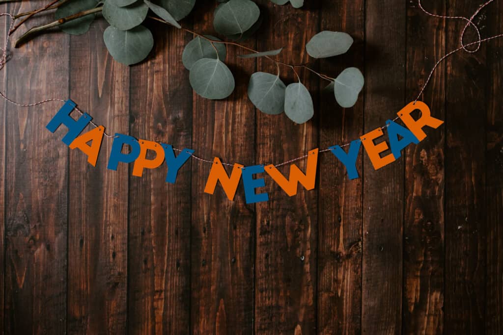 "Happy New Year" Schriftzug vor einem hölzernem Hintergrund